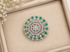 Stunning Ring, intricately crafted brooch with floral motif and sparkling clear and emerald stones.